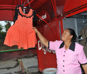 Ita Burnett hangs one of her outfits for sale at the front of her stall in Half-way Tree