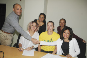 Mr. Phillip Bernard (left), General Manager of JN Small Business Loans (JNSBL) shakes hands with Miss Lisandra Rickards (right), Entrepreneurship Programme Manager at Branson Centre of Entrepreneurship Caribbean (BCoEC) at the signing of the agreement to disburse loans to three entrepreneurs at the JNSBL Offices recently. The three were the winners in the BCoEC Pitch To Rich competition last year. Looking on are: Victoria Silvera, owner of Touch By VLS (second left); Michelle Jones, Executive Producer of Vibes Cuisine (third left); Joshua Chamberlain, who manages Special Projects at Alpha Boys School (centre); and Thelma Yong, Credit and Risk Assessment Manager at JNSBL (second right)   