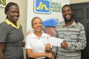 Michael Levy (right), smiles as he receives his prize of a weekend for two at Iberostar Hotel from Thelma Yong, Deputy General Manager at JN Small Business Loans (JNSBL) after he won the Valentine’s Day BizEvents Loans Promotions held from January 26, to February 13, 2015. Also present at the handing over is Candice Campbell-Boyd, Credit Relations Officer at JNSBL. 
