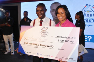 Marlon Phillips (left) displays his cash prize with Mrs. Gillian Hyde, General Manager of JN Small Business Loans after he finished third in the JNSBL Barber and Beauty Expo in February.