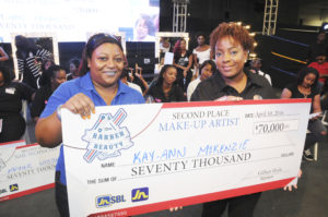 Kay-Ann McKenzie (right) second place winner in the Make-Up category of the JN Small Business Loans (JNSBL) Barber and Beauty Battle smiles as she receives a replica of her prize money from Keisha Bent, Senior Manager, Finance at JNSBL. The JNSBL Barber and Beauty Battle was held in April. 