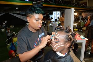 Make-up artist Debbie Manning applies make-up on her model during the final theme, Africa Futuristic, during the JNSBL Barber and Beauty Battle held at the National Arena on Sunday, July 1.